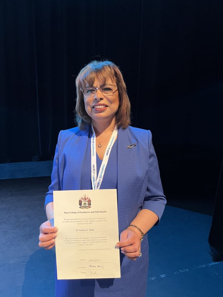 Doctor Nashwa Matta stands with her award after presentation at conference in Liverpool