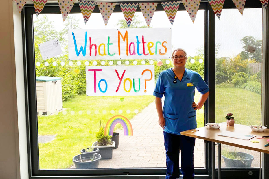 Jenn Wyld, standing in front of "What Matters To You?" bunting.