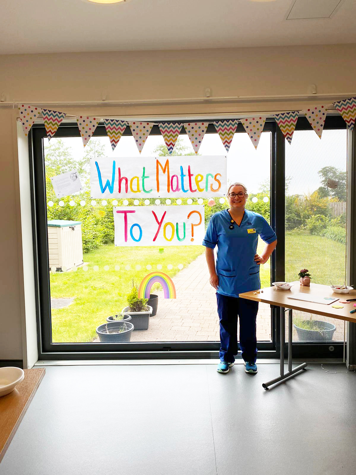 Jenn Wyld, standing in front of "What Matters To You?" bunting.