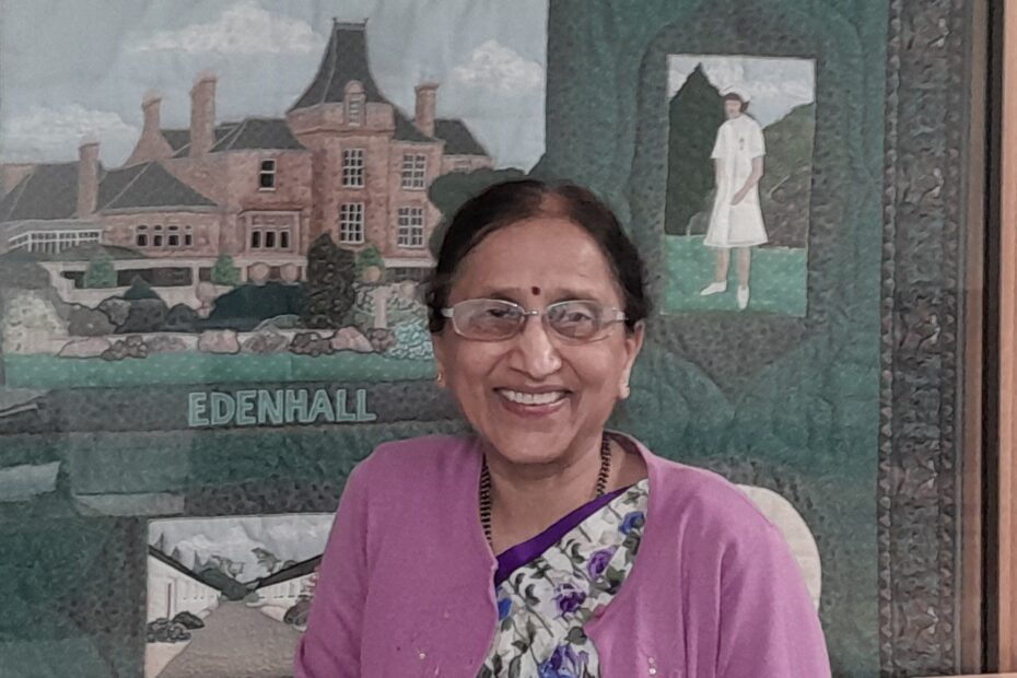 Dr Mahandra Verappa Jigajinni - affectionately known as Dr Jig - smiling with tapestry of Edenhall Hpspital in background