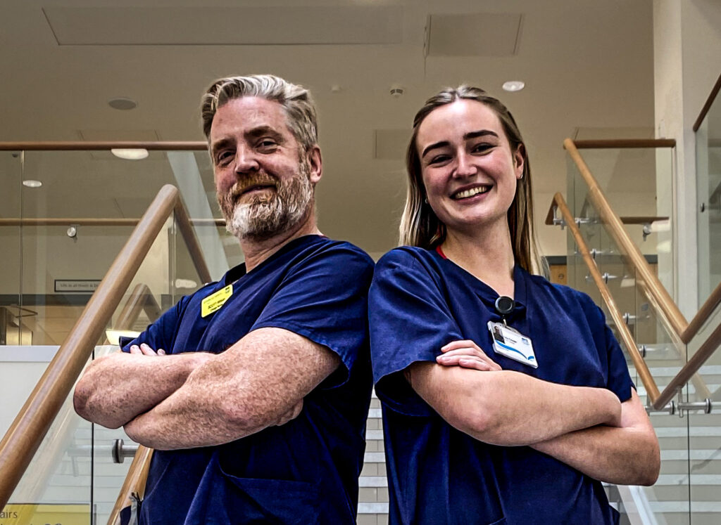 Nurses Scott Wilson and Clio Cooter stand smiling side by side after winning a major prize for the presentation on patient experience.