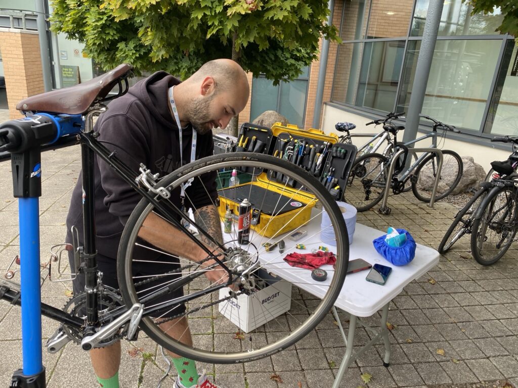 Active travel officer Claudio Pia works on a bicycle outside a hospital.