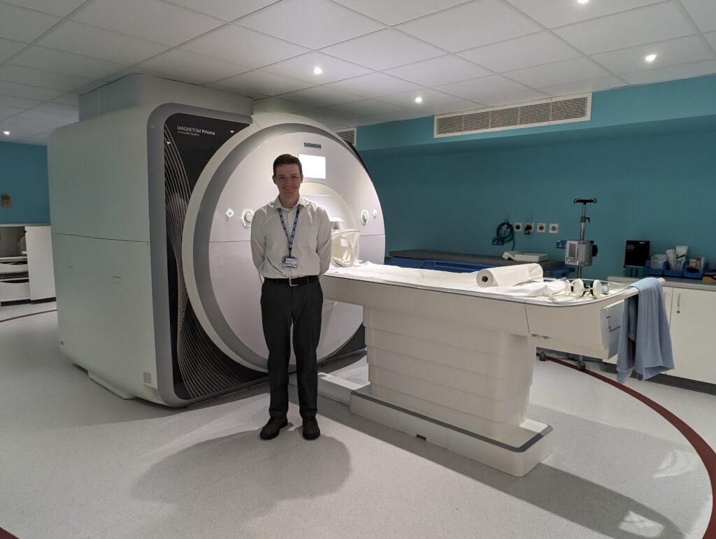 George Bruce beside one of NHSGGC's MRI scanners