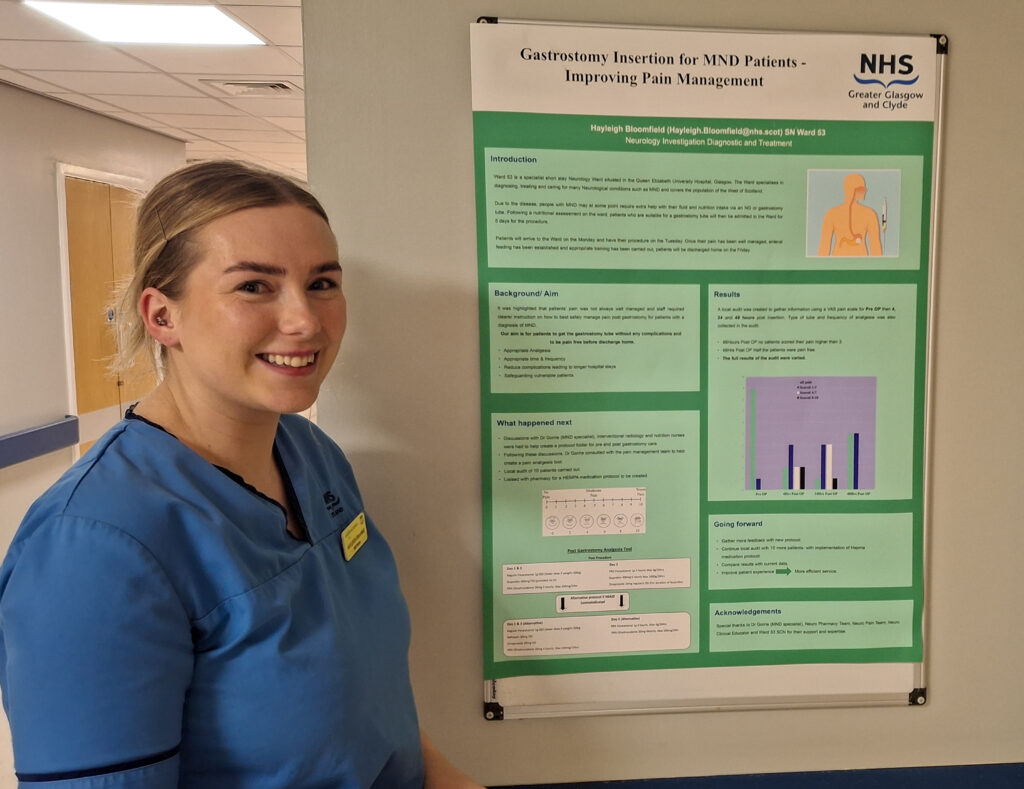 Staff nurse Hayleigh Bloomfield stands beside her award-winning poster