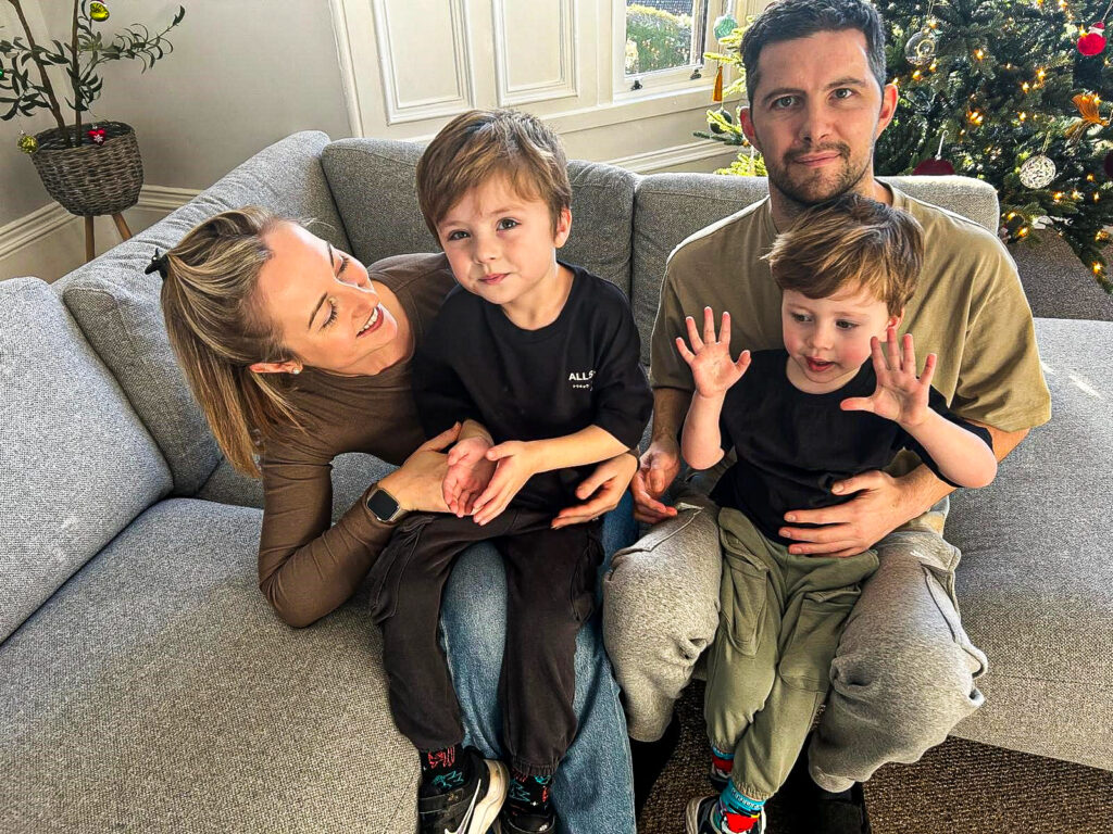 Scott Gold, his wife and two sons, sitting smiling on the settee at their Paisley home